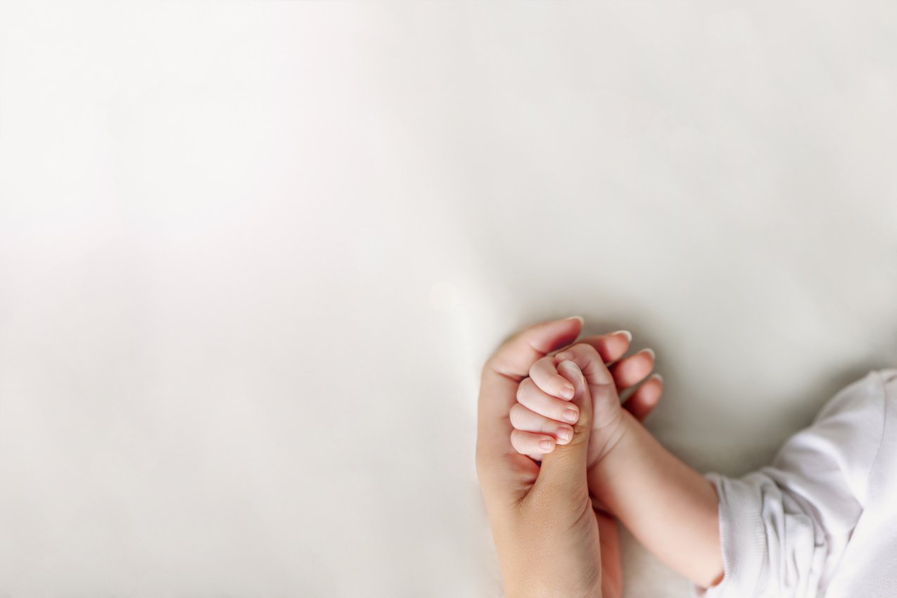 Mother's Hand Holding Baby's